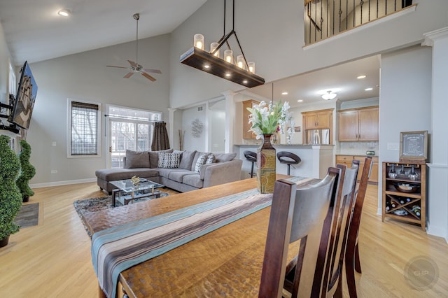 dining room with light wood finished floors, recessed lighting, a ceiling fan, high vaulted ceiling, and baseboards