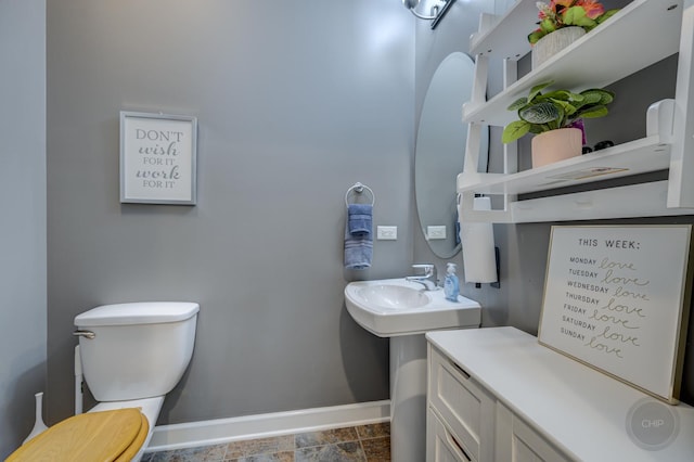 bathroom with toilet and baseboards