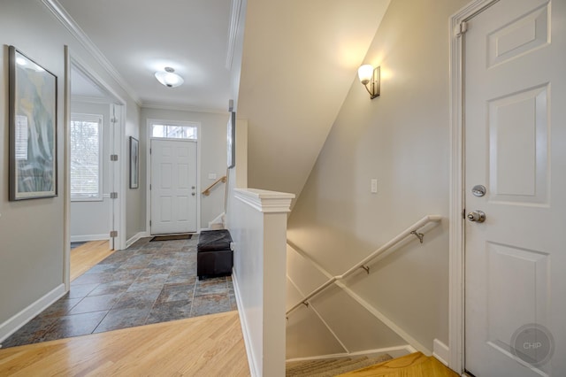 foyer entrance featuring baseboards, ornamental molding, and wood finished floors