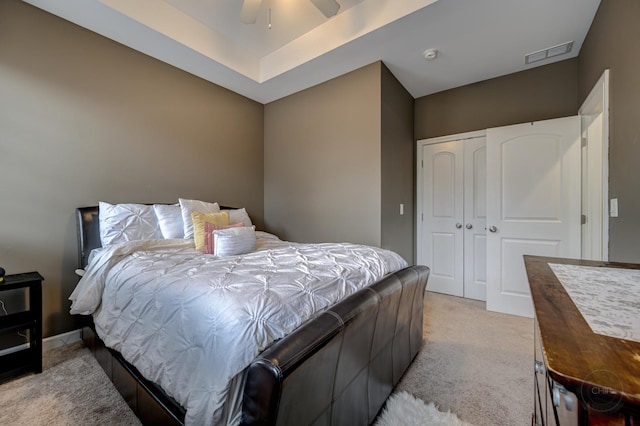 bedroom with ceiling fan, a closet, visible vents, and light colored carpet