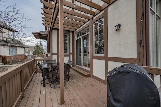 deck featuring outdoor dining area, a pergola, and area for grilling