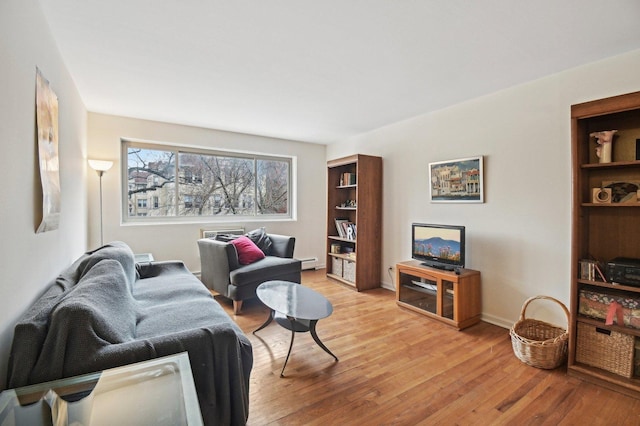 living area featuring a baseboard radiator, light wood-style flooring, and baseboards