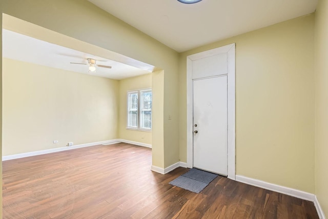 foyer entrance with baseboards, dark wood-type flooring, and a ceiling fan