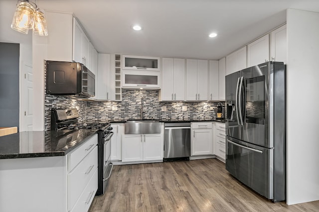 kitchen featuring backsplash, stainless steel appliances, a sink, and wood finished floors