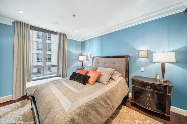 bedroom with baseboards, ornamental molding, and wood finished floors