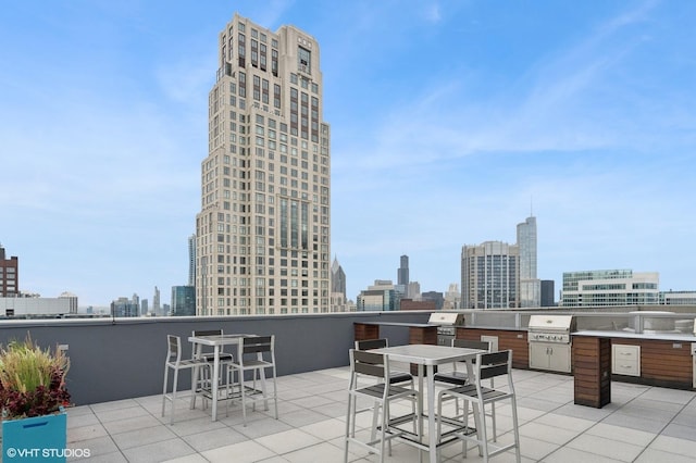 view of patio featuring outdoor dining space, area for grilling, and a city view