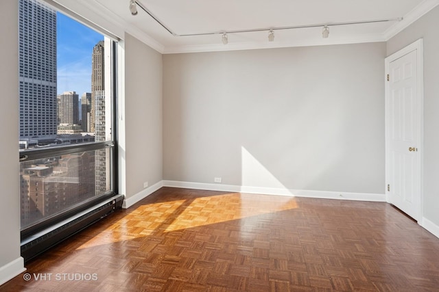 empty room featuring baseboards, a view of city, and crown molding