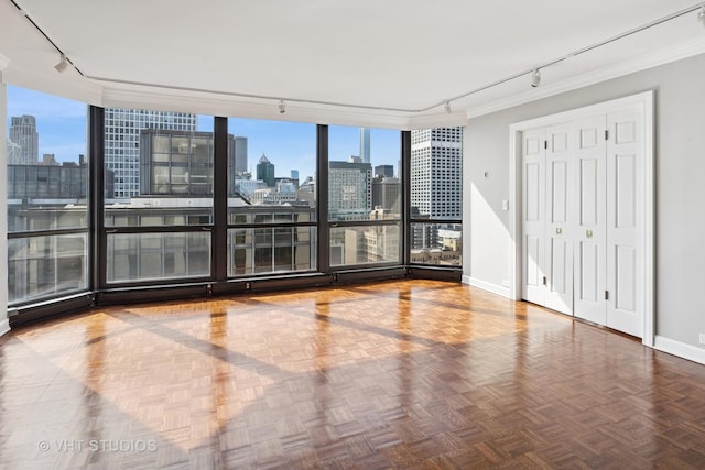 spare room featuring a city view, crown molding, plenty of natural light, and rail lighting