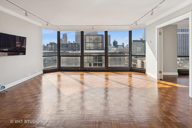 spare room featuring plenty of natural light, rail lighting, and a view of city