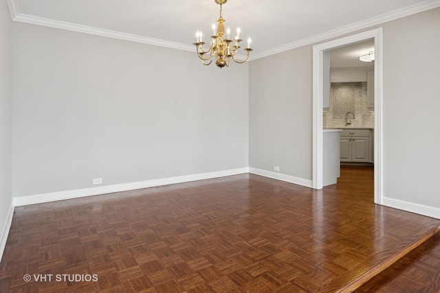 spare room featuring a sink, baseboards, a notable chandelier, and ornamental molding