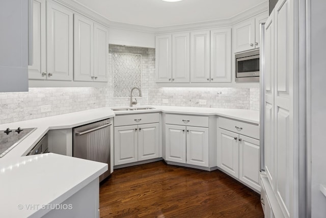 kitchen with a sink, backsplash, white cabinetry, and stainless steel appliances