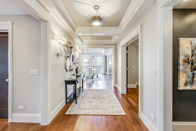 corridor with crown molding, baseboards, and wood finished floors