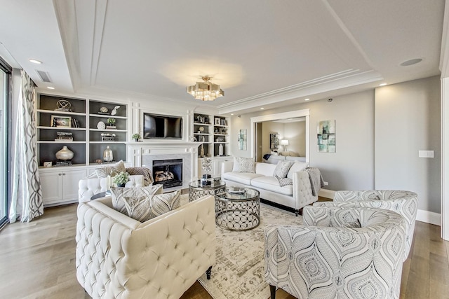 living area featuring visible vents, baseboards, recessed lighting, a high end fireplace, and light wood-style floors