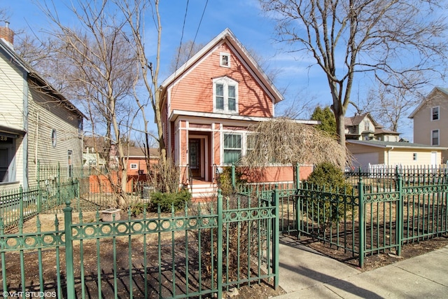 view of front of house with covered porch, brick siding, a fenced front yard, and a gate