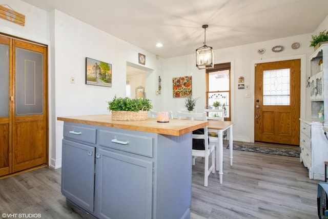 kitchen with recessed lighting, butcher block counters, decorative light fixtures, and light wood-style flooring