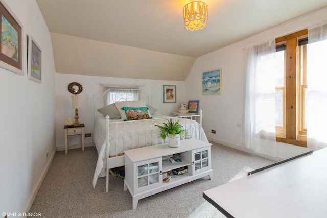 bedroom with lofted ceiling, light colored carpet, and baseboards