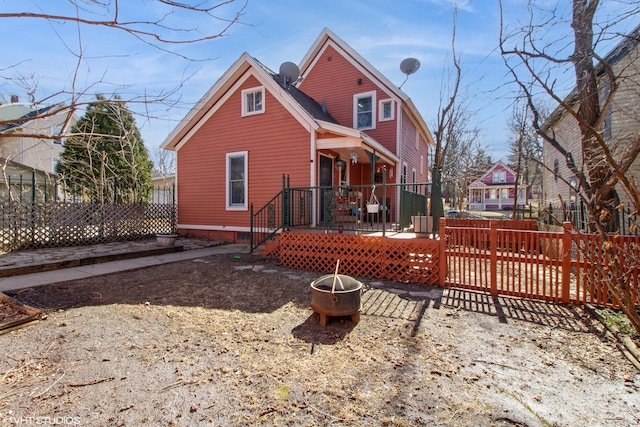 rear view of property with fence and a deck