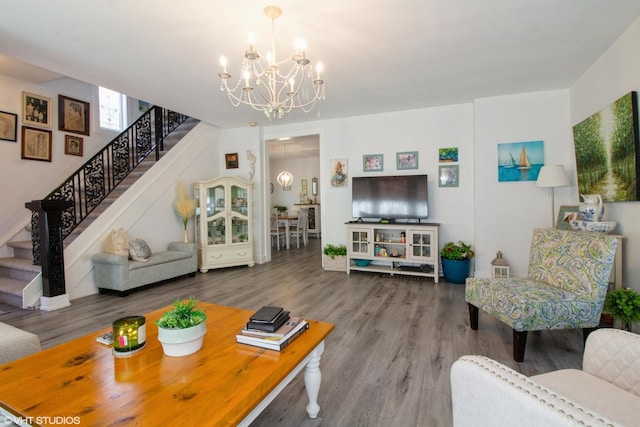 living room with wood finished floors, a notable chandelier, and stairs