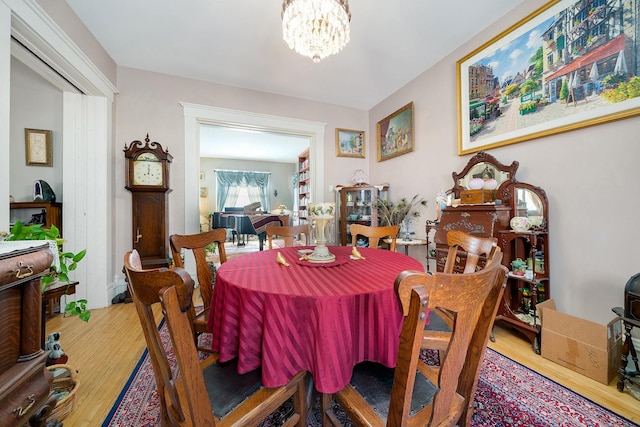 dining space with a notable chandelier and wood finished floors