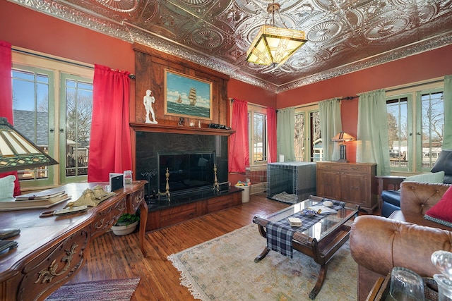 living area featuring an ornate ceiling, wood finished floors, and a high end fireplace