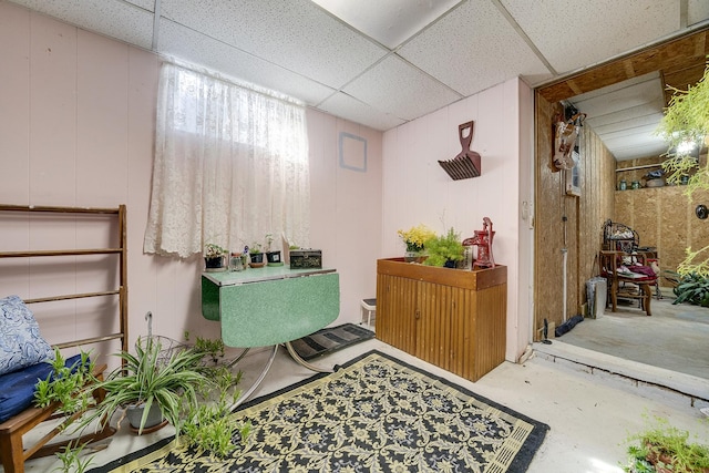 bathroom featuring a paneled ceiling, walk in shower, and concrete flooring