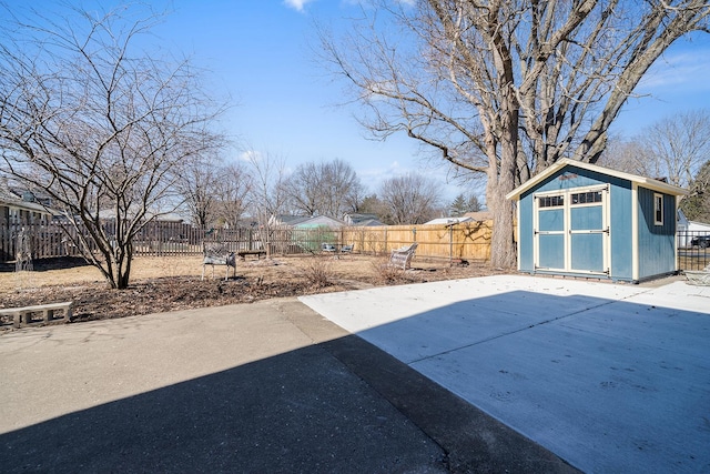 view of patio / terrace with an outbuilding, a fenced backyard, and a storage unit