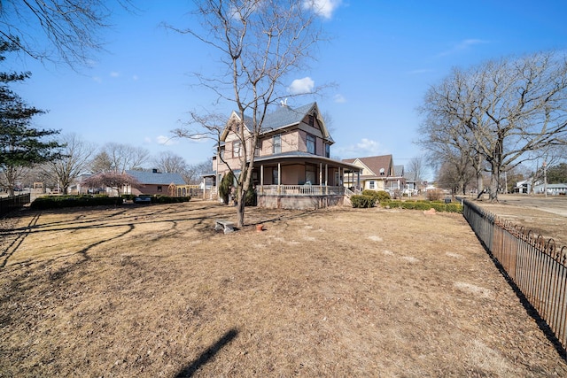 back of property with covered porch and fence