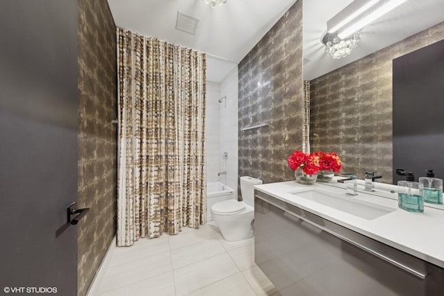 bathroom with toilet, vanity, tile walls, tile patterned floors, and shower / bath combo