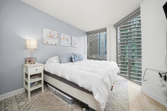 bedroom featuring baseboards and wood finished floors