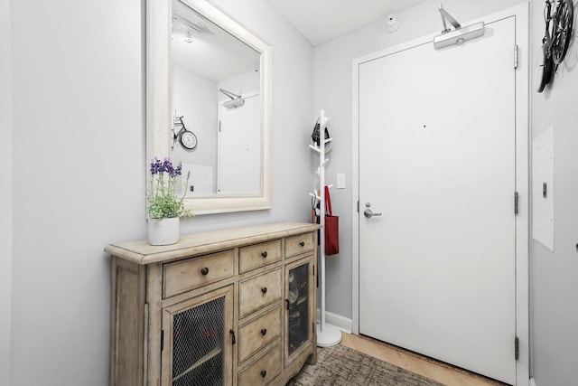 doorway to outside with light wood-style flooring and baseboards