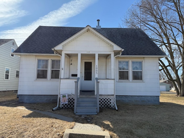 bungalow featuring roof with shingles