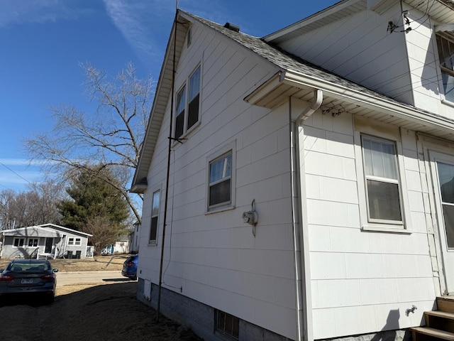 view of home's exterior with roof with shingles