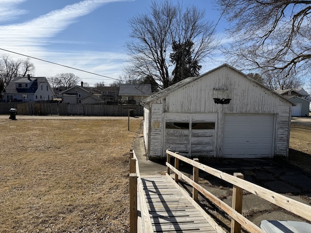 detached garage with fence and a residential view