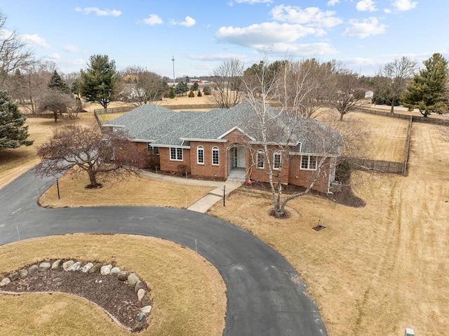 single story home featuring a shingled roof, brick siding, and driveway