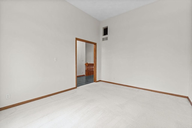 empty room featuring light colored carpet, visible vents, and baseboards