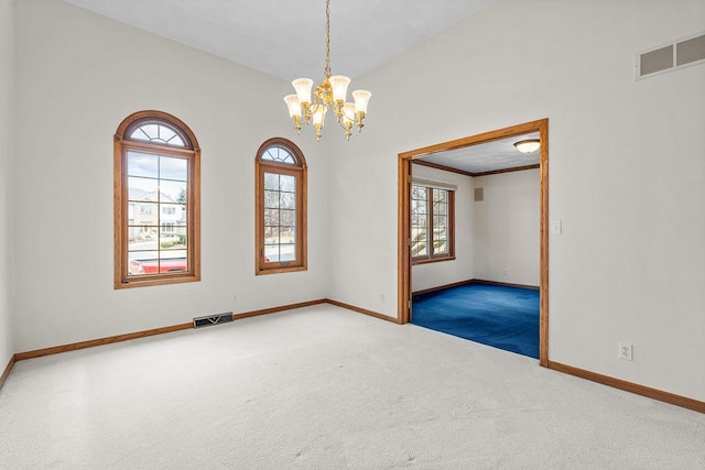 spare room with a chandelier, carpet, visible vents, and baseboards