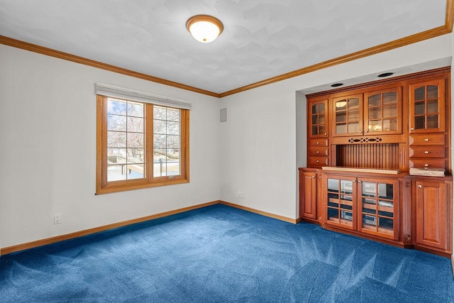 empty room featuring ornamental molding, dark carpet, and baseboards