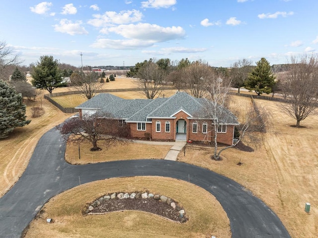 view of front of house featuring driveway, a shingled roof, and brick siding