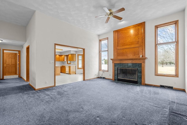 unfurnished living room featuring light carpet, baseboards, visible vents, and a tile fireplace