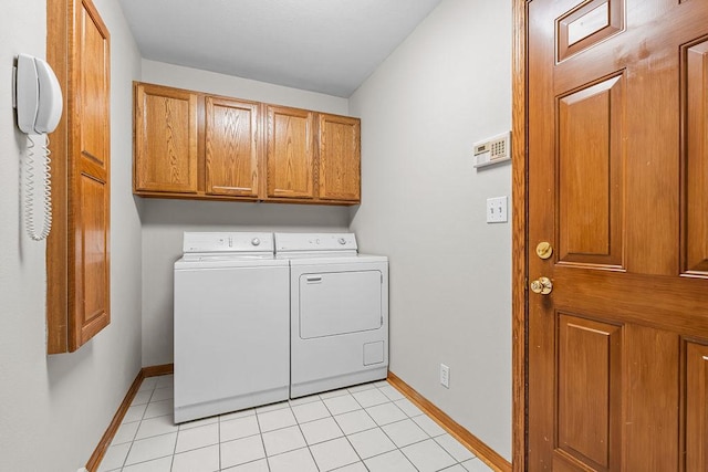 clothes washing area with cabinet space, independent washer and dryer, baseboards, and light tile patterned flooring