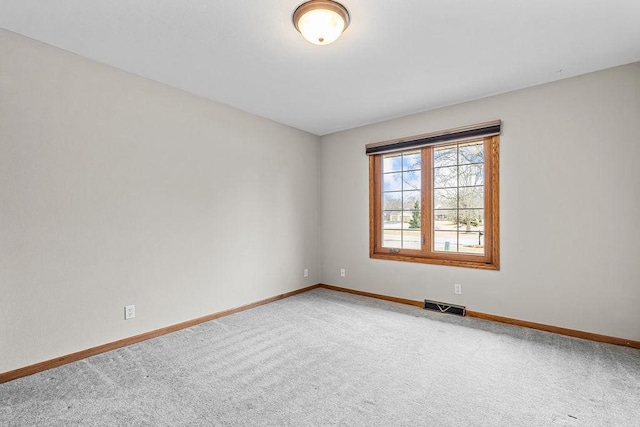 spare room with carpet flooring, visible vents, and baseboards