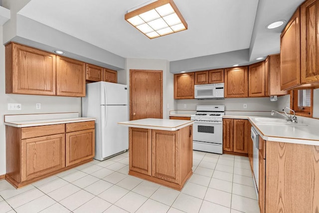 kitchen featuring light countertops, white appliances, a sink, and a center island