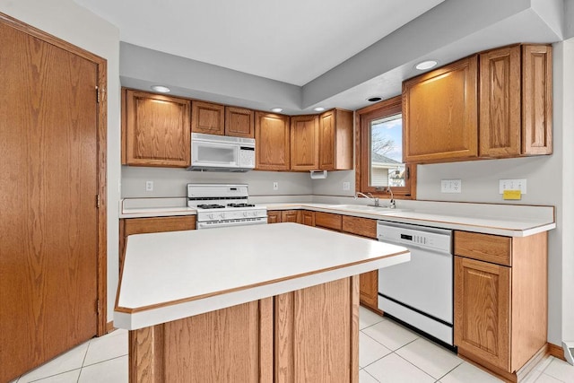 kitchen featuring white appliances, light tile patterned floors, a kitchen island, and light countertops