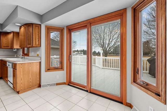 doorway featuring light tile patterned floors, visible vents, baseboards, and a sink