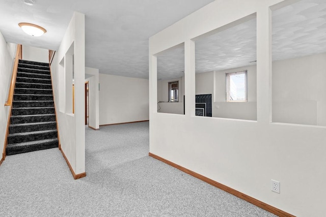 below grade area with carpet floors, baseboards, and stairs