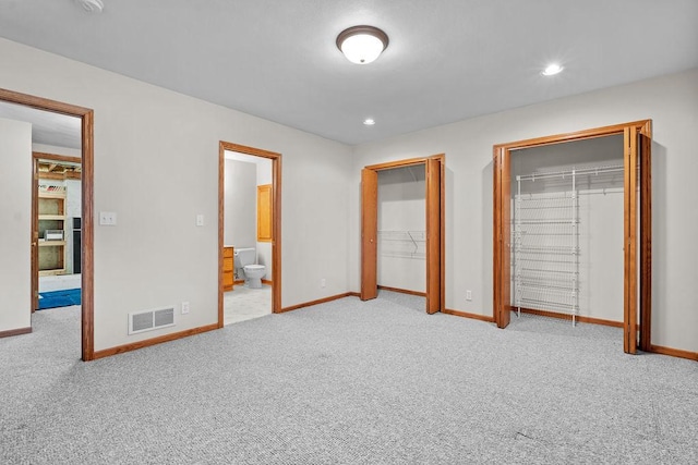 unfurnished bedroom with recessed lighting, carpet floors, visible vents, baseboards, and multiple closets