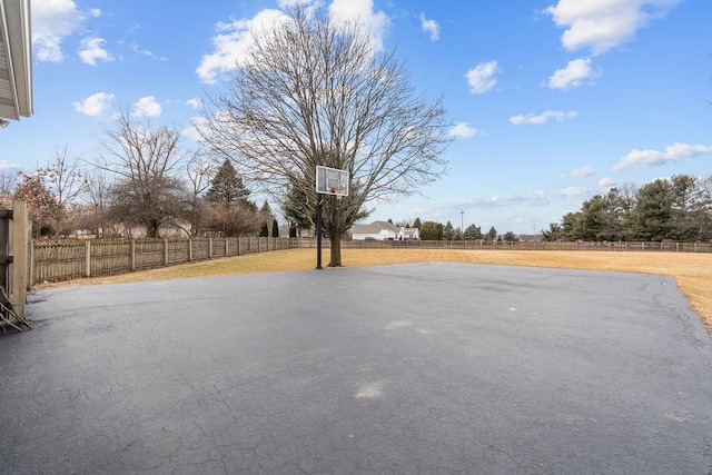 exterior space featuring basketball hoop and fence