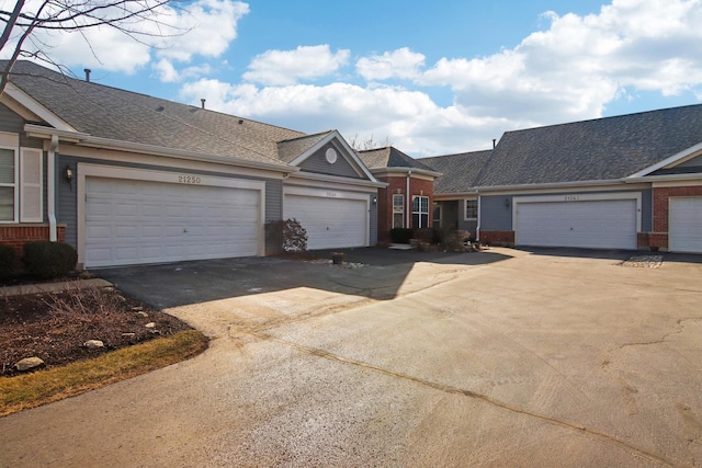 single story home with a shingled roof and brick siding