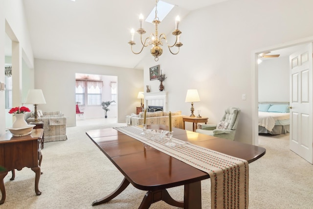 living area with carpet, high vaulted ceiling, a tiled fireplace, and a notable chandelier