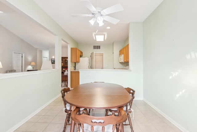 dining room with visible vents, ceiling fan, baseboards, and light tile patterned floors